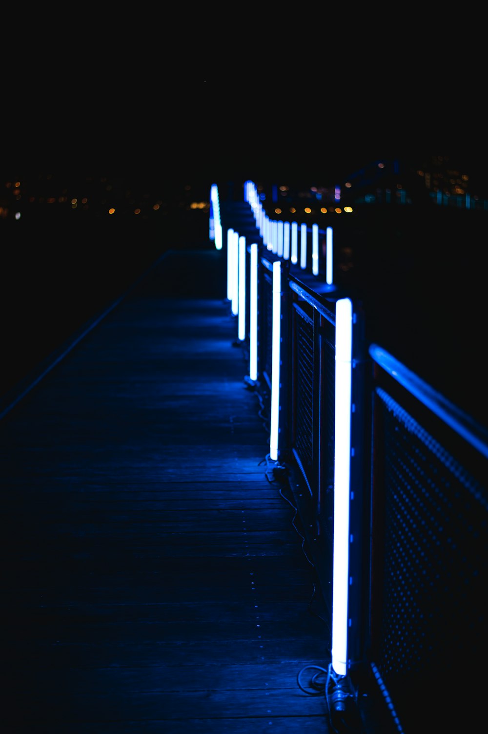 a row of lights that are on the side of a fence