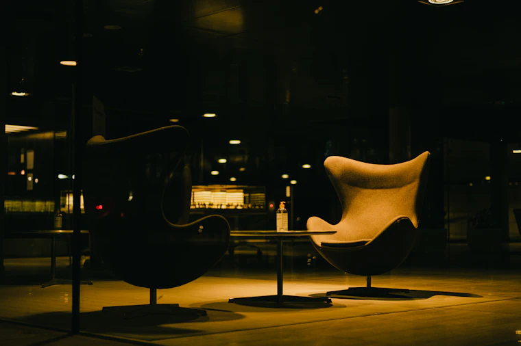Warmly lit reading corner with a brass floor lamp and a leather armchair