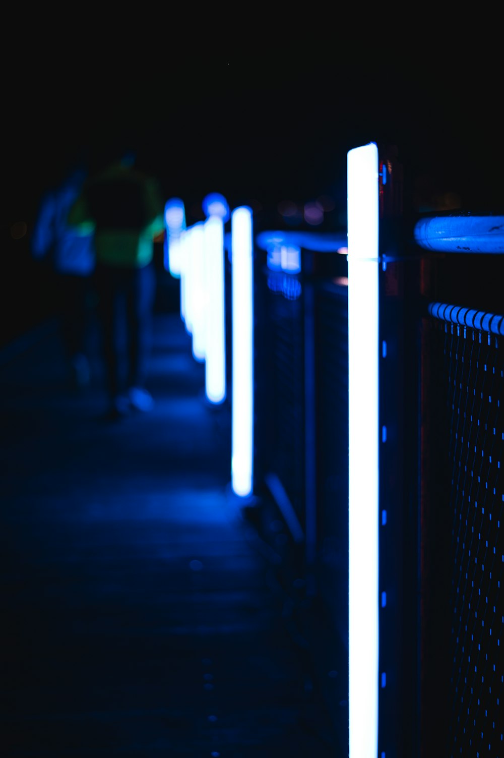 a person walking down a sidewalk at night