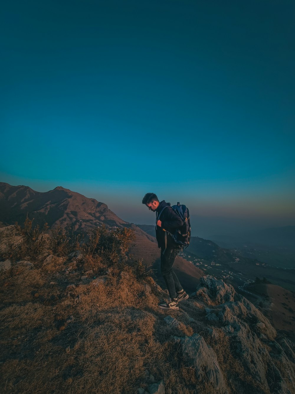 a man standing on top of a mountain with a backpack