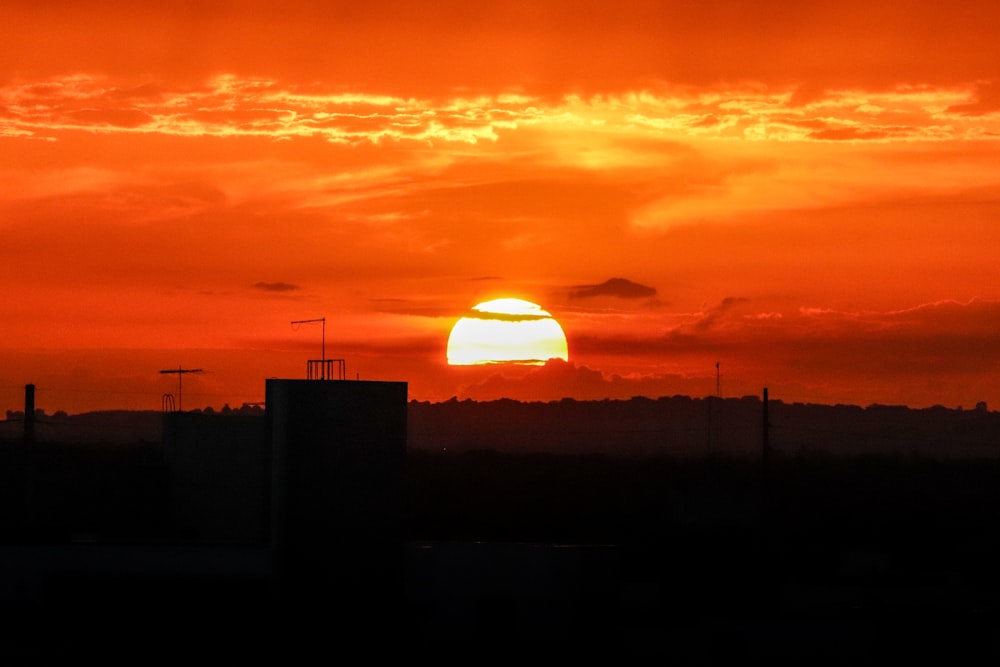 the sun is setting over the horizon of a city