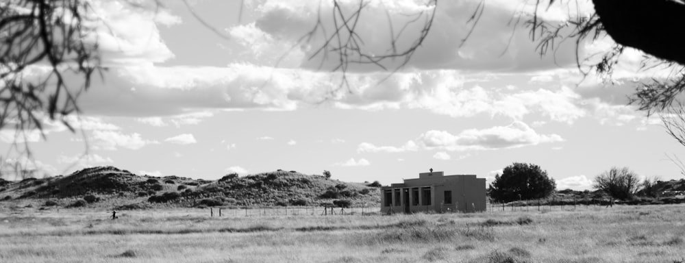 a black and white photo of a house in the middle of a field