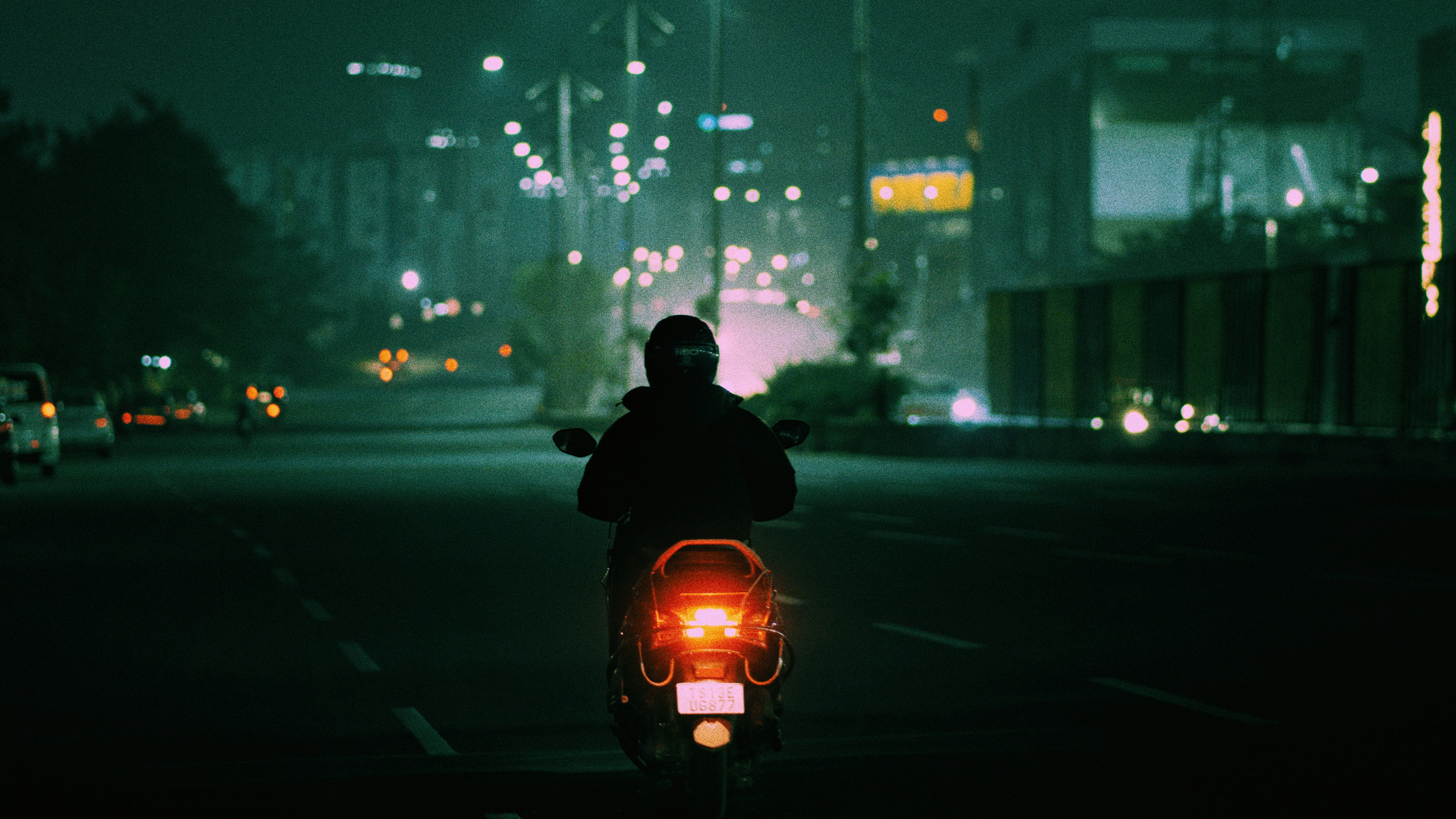 a man riding a motorcycle down a street at night