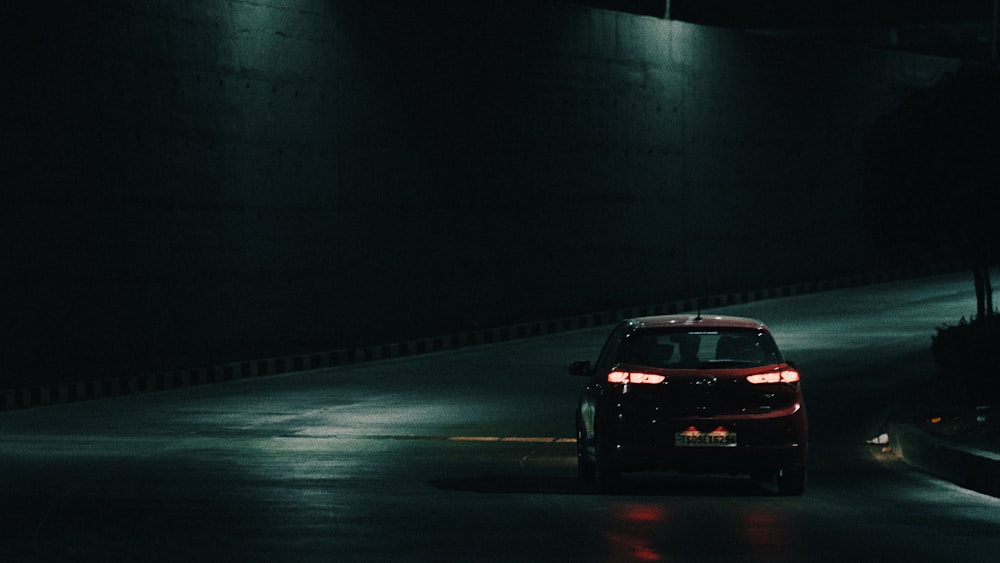 a car driving down a dark street at night
