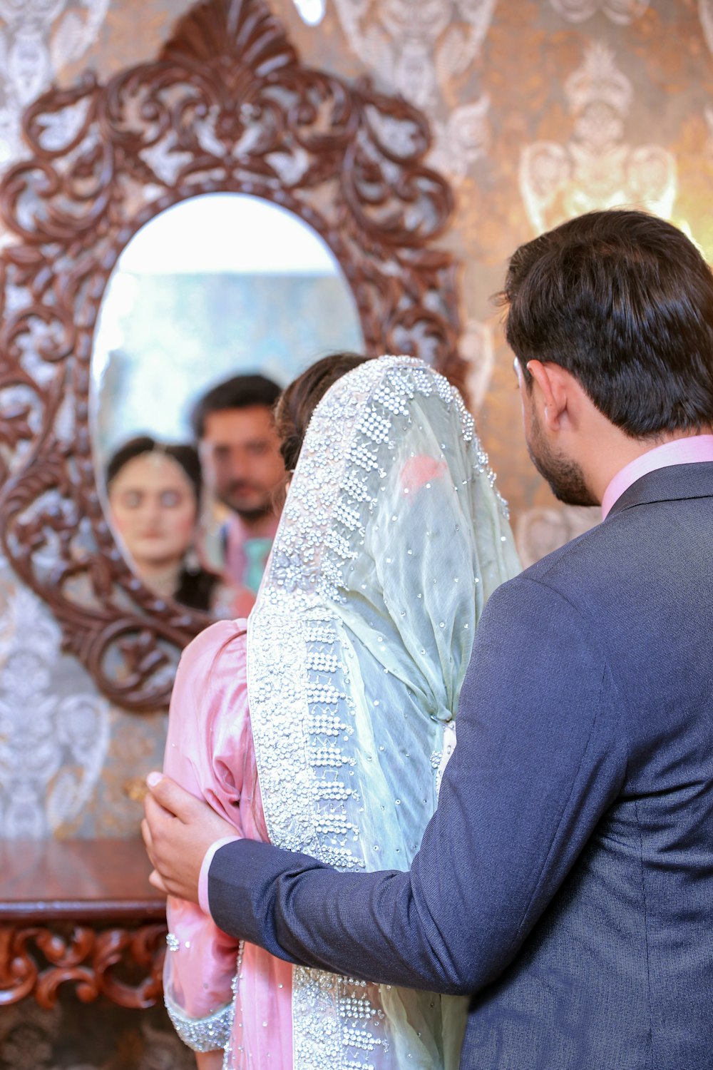 a man and woman standing in front of a mirror