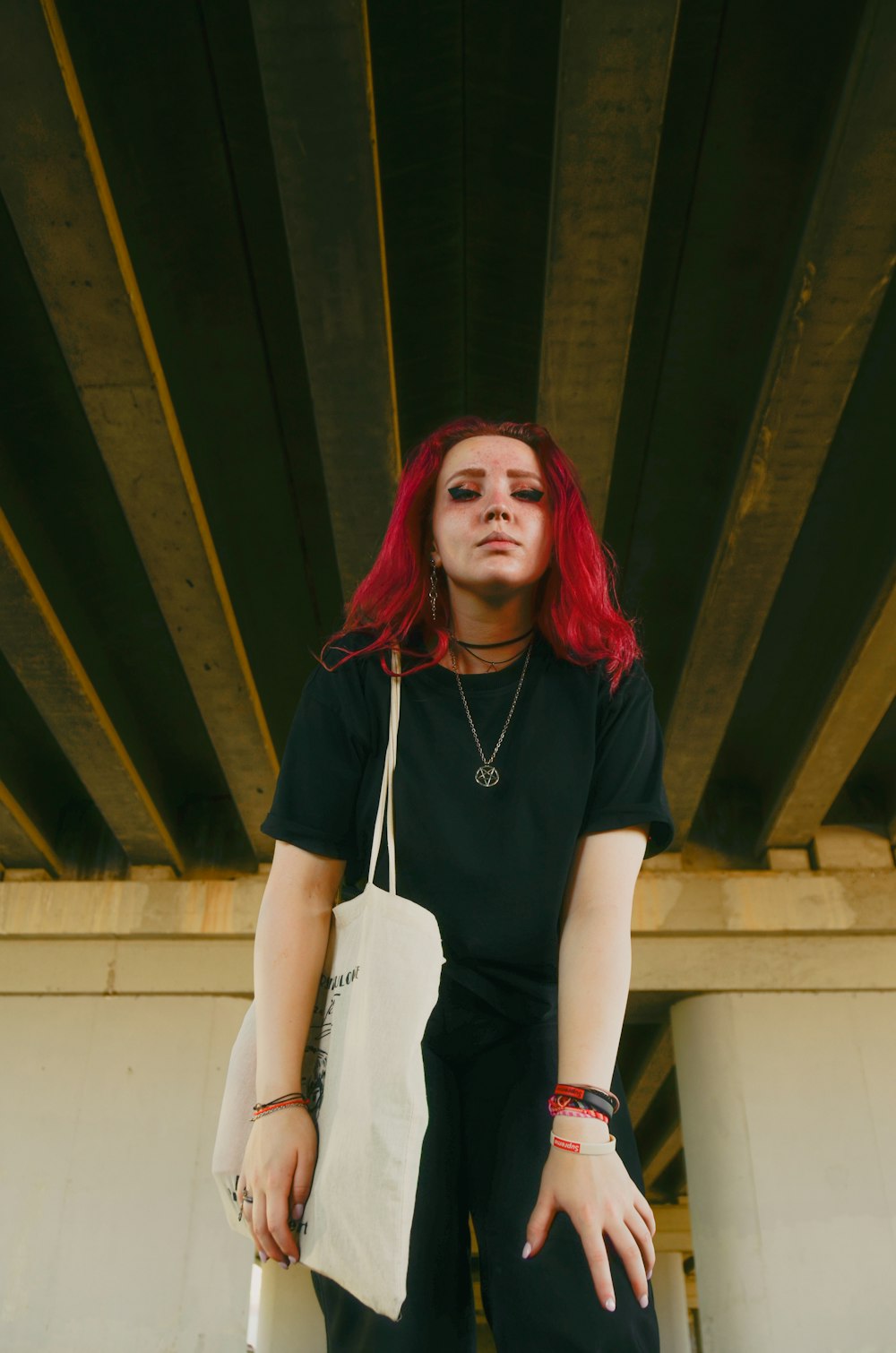 a woman with red hair holding a white bag