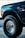 a blue truck with big tires parked in a parking lot