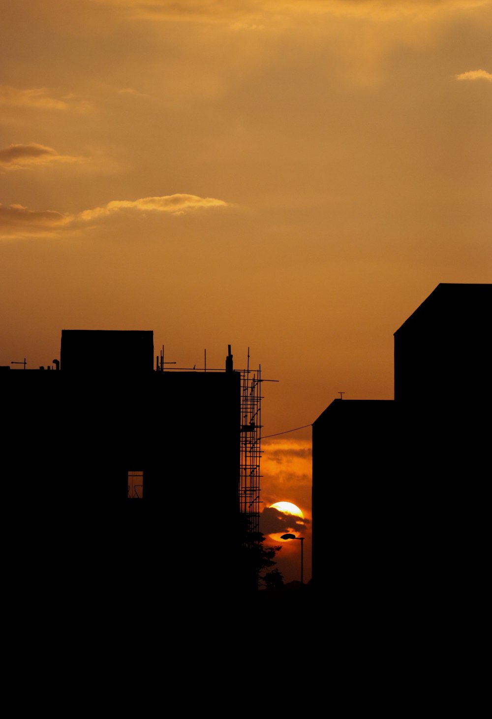 the sun is setting behind some buildings