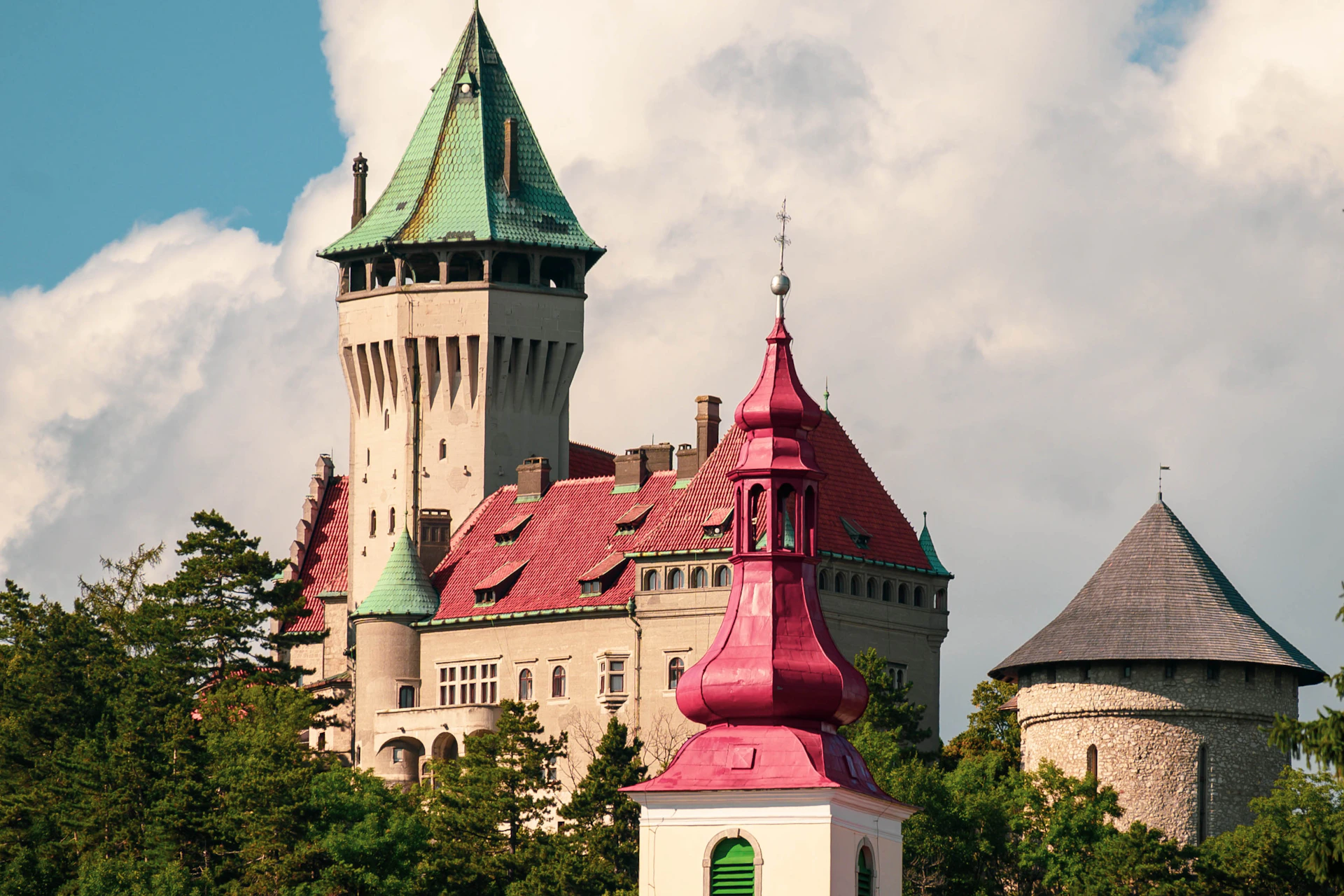 a large building with a green roof and two towers