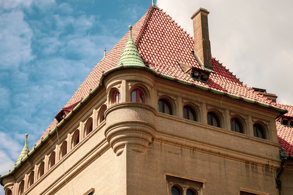 a tall building with a red roof and a green top