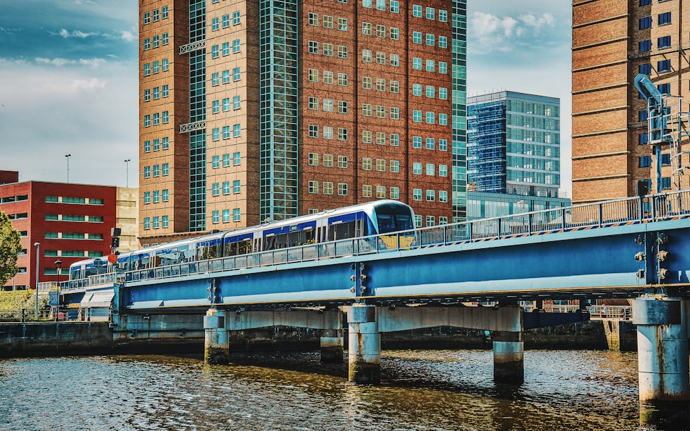 a blue and white train traveling over a bridge