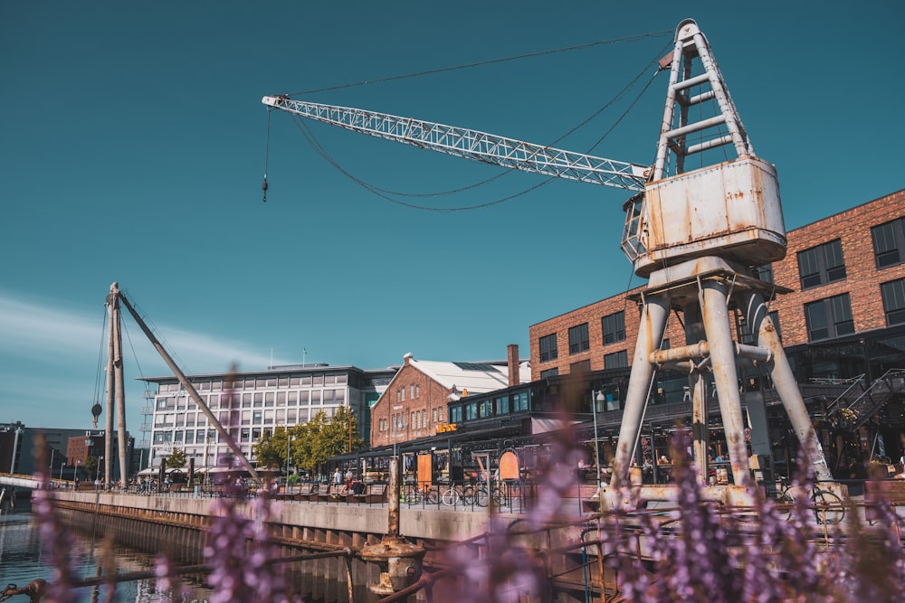 a crane sitting on top of a bridge next to a river