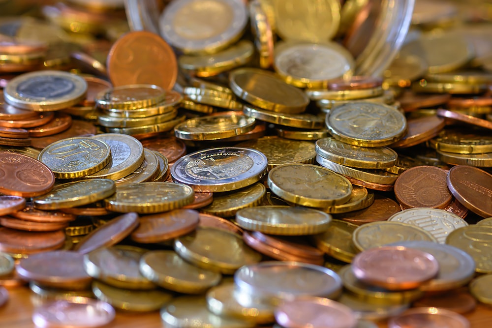 a pile of coins sitting on top of a wooden table