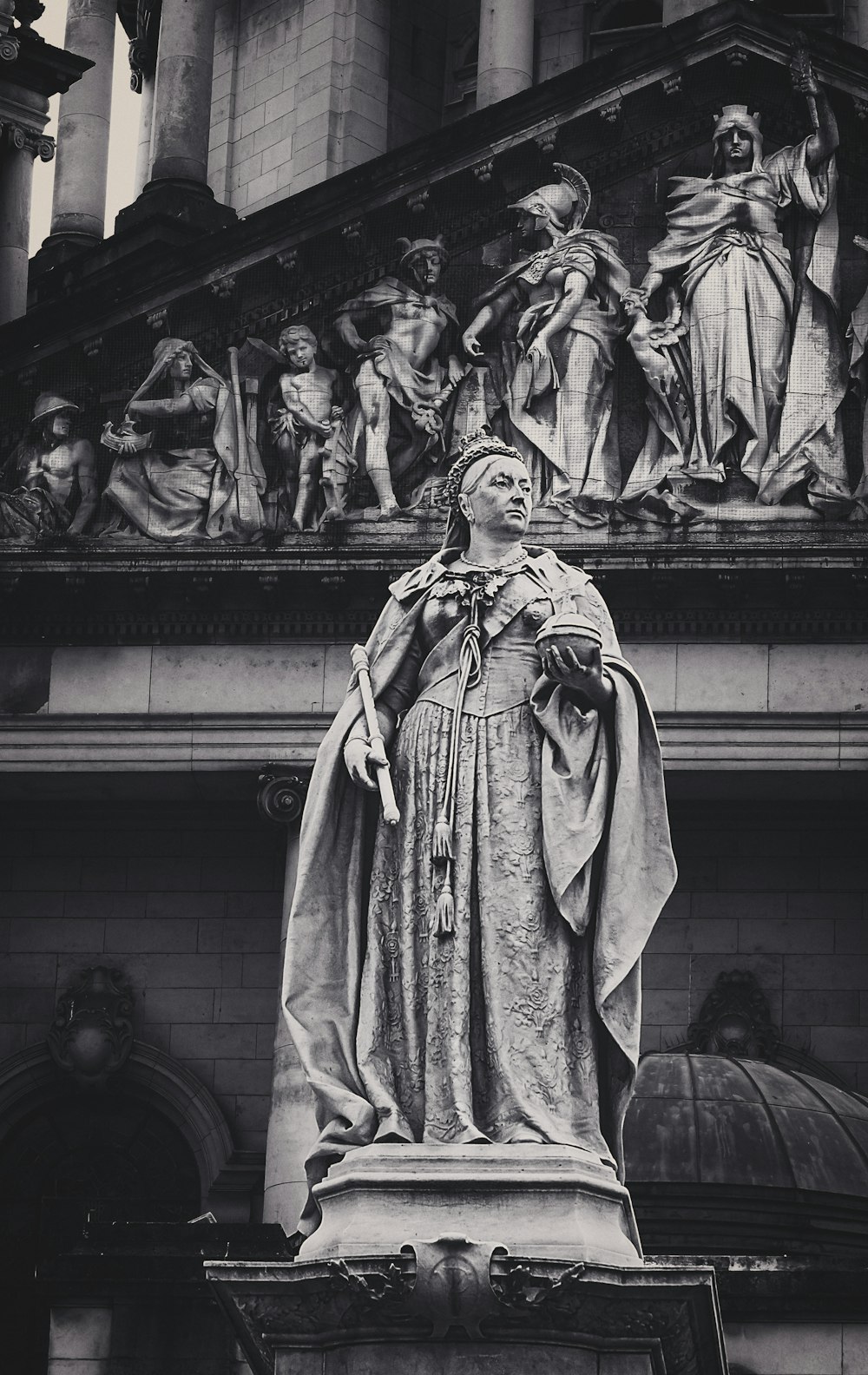 a black and white photo of a statue in front of a building