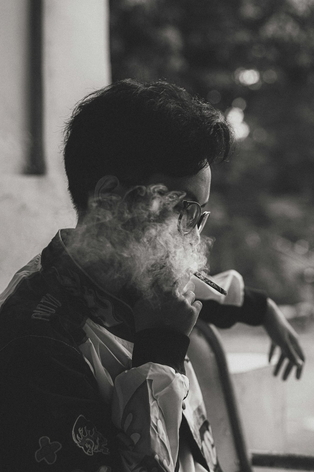 a man smoking a cigarette in a black and white photo