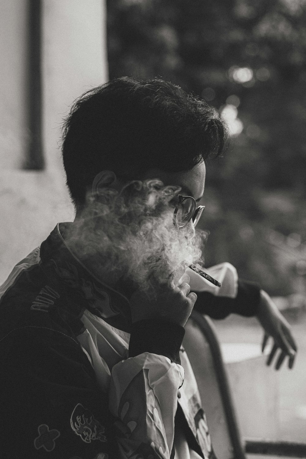 Ein Mann, der eine Zigarette raucht, auf einem Schwarz-Weiß-Foto