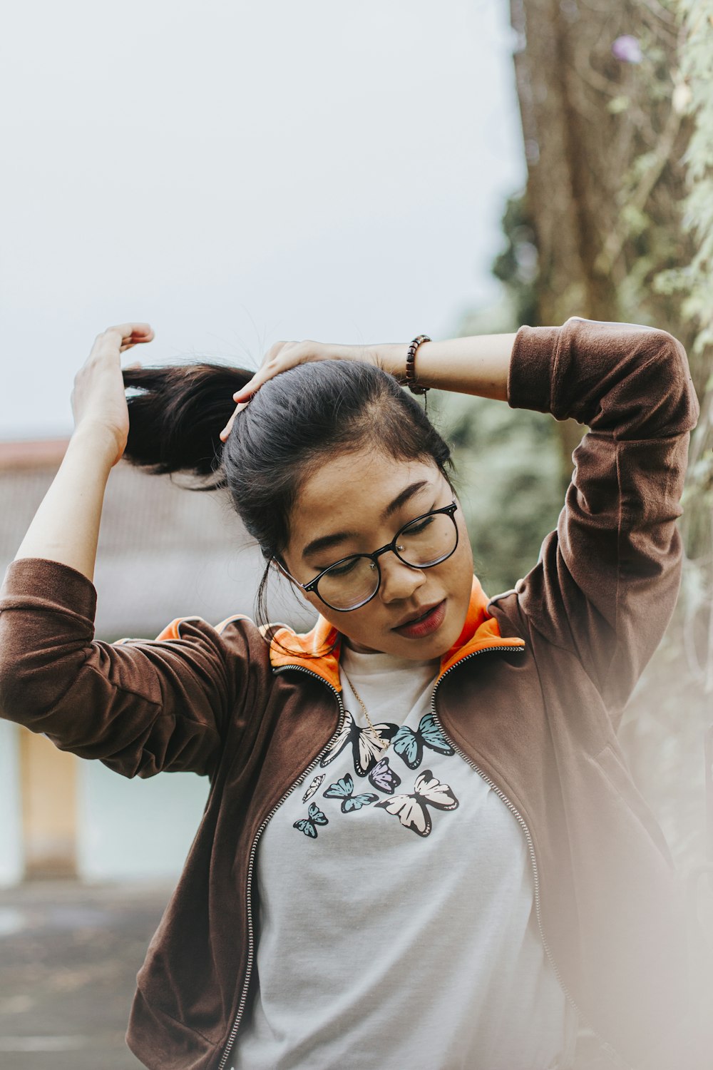 a woman wearing glasses and a brown jacket