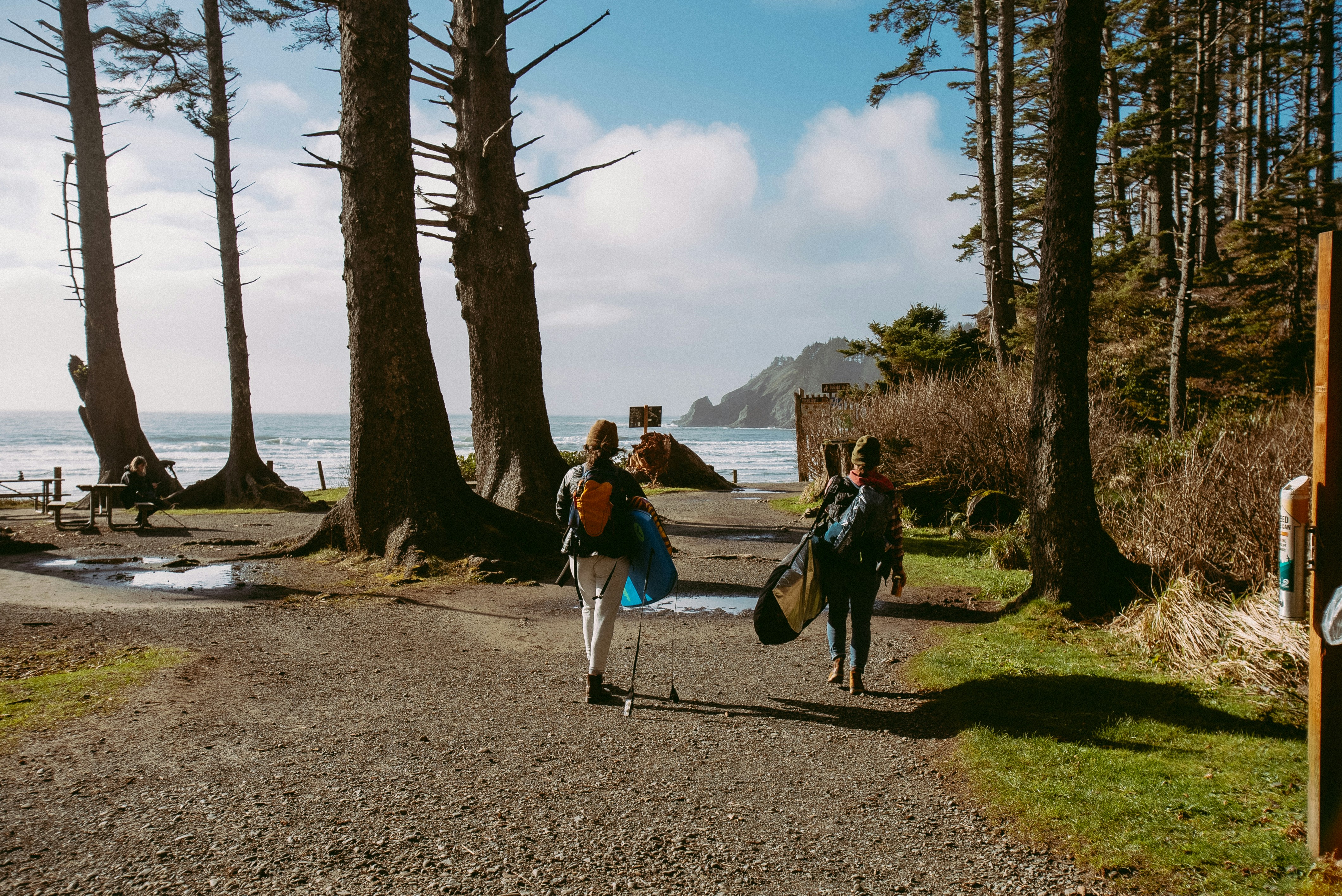 a couple of people walking down a dirt road