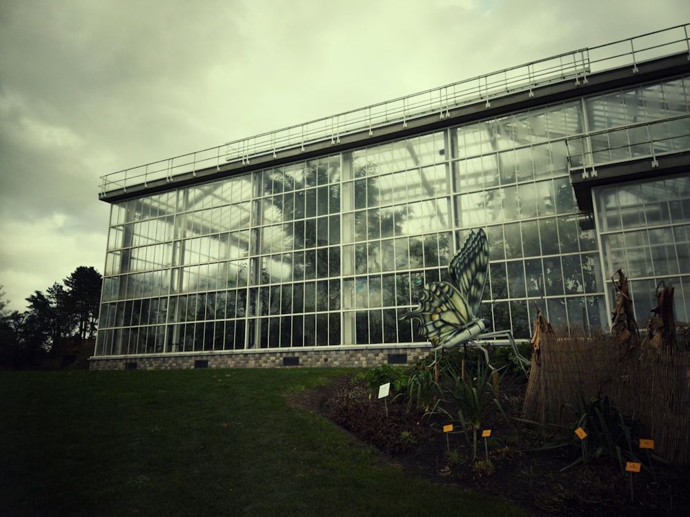 a large glass building sitting on top of a lush green field