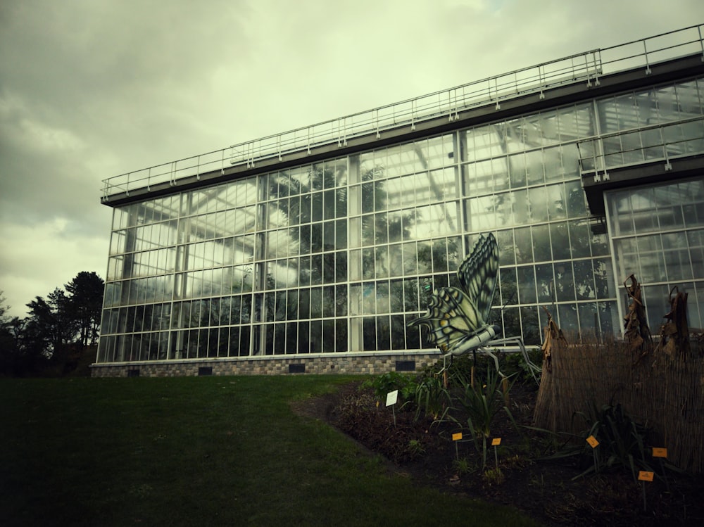 Ein großes Glasgebäude auf einer üppigen grünen Wiese
