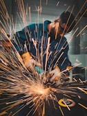 a man working on a piece of metal with a grinder