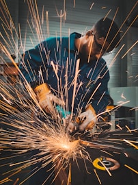 a man working on a piece of metal with a grinder