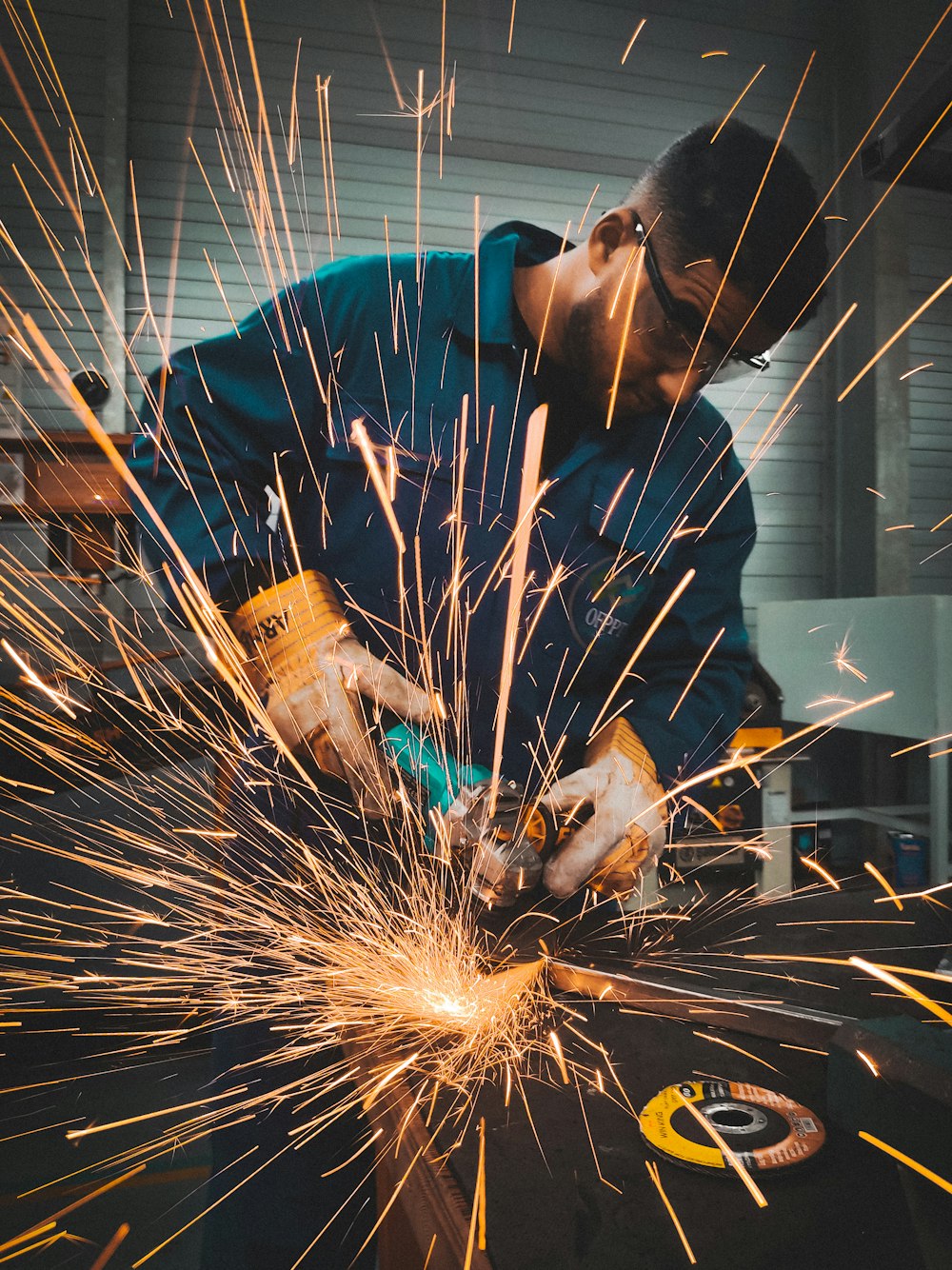 a man working on a piece of metal with a grinder