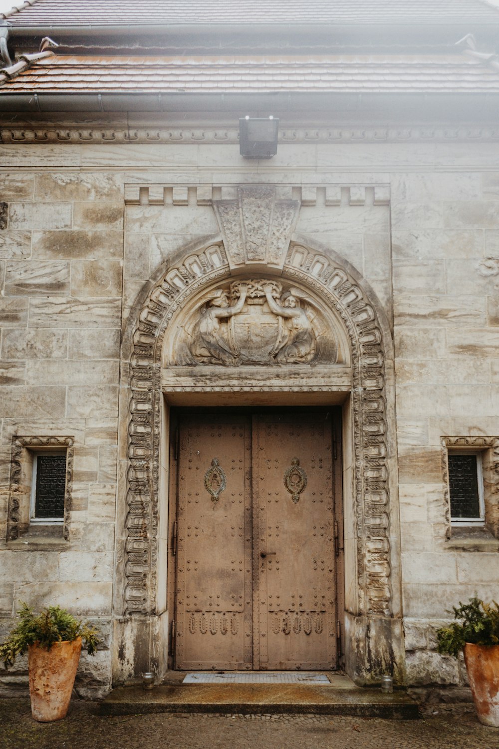 a stone building with two large wooden doors