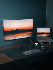 a desk with a laptop and a monitor on it