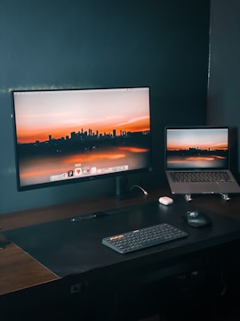 a desk with a laptop and a monitor on it
