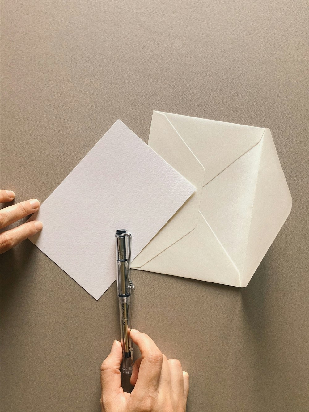 a person cutting out a piece of paper with a pen