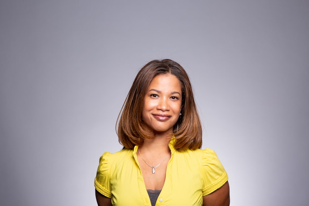 a woman in a yellow shirt posing for a picture