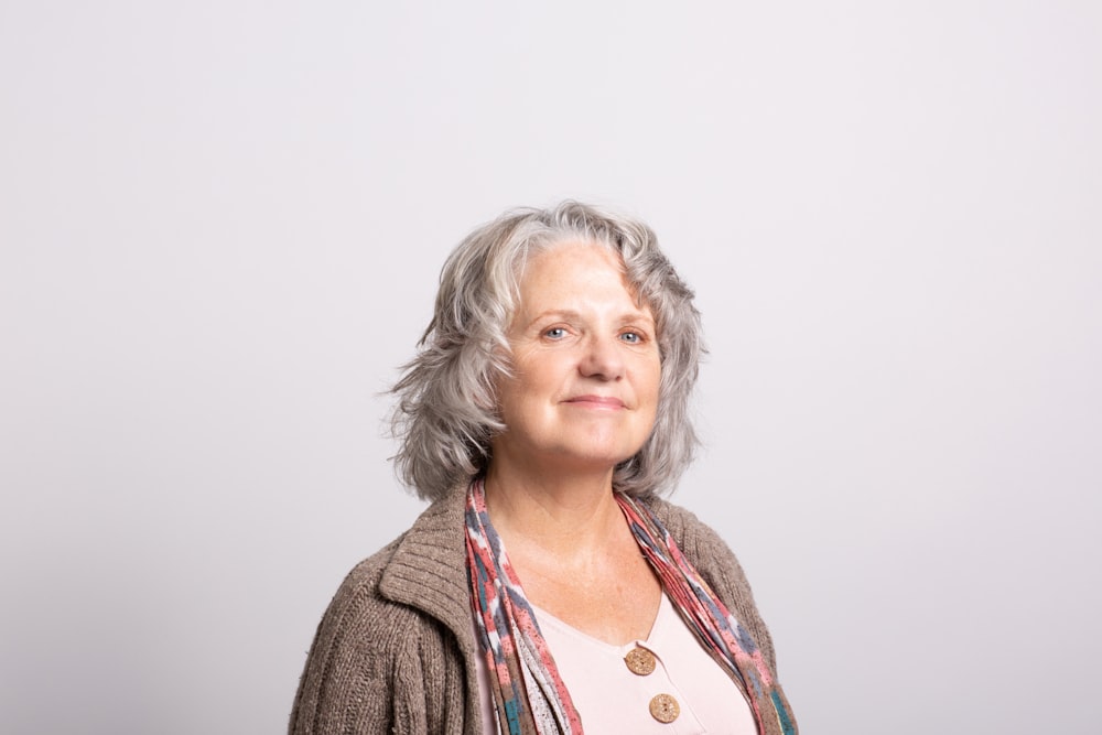 uma mulher com cabelos grisalhos vestindo um cardigã marrom