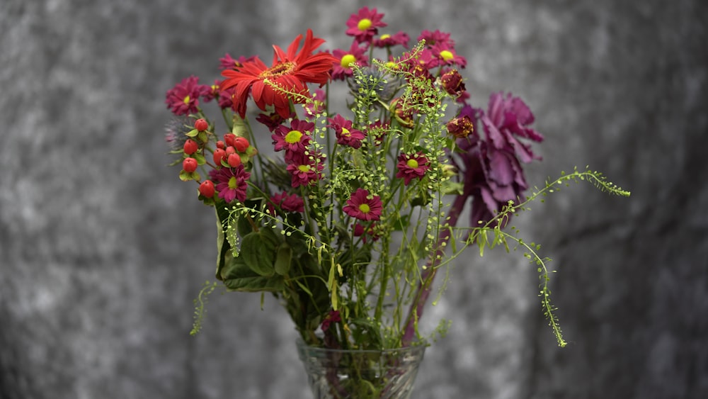 a vase filled with red and purple flowers