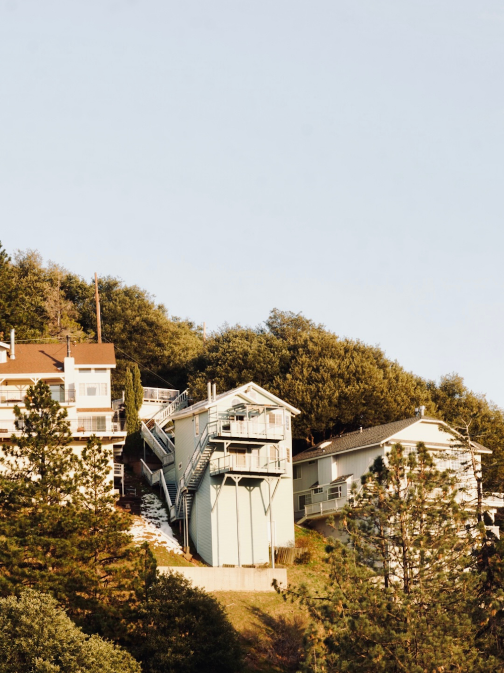 a house on a hill with trees surrounding it