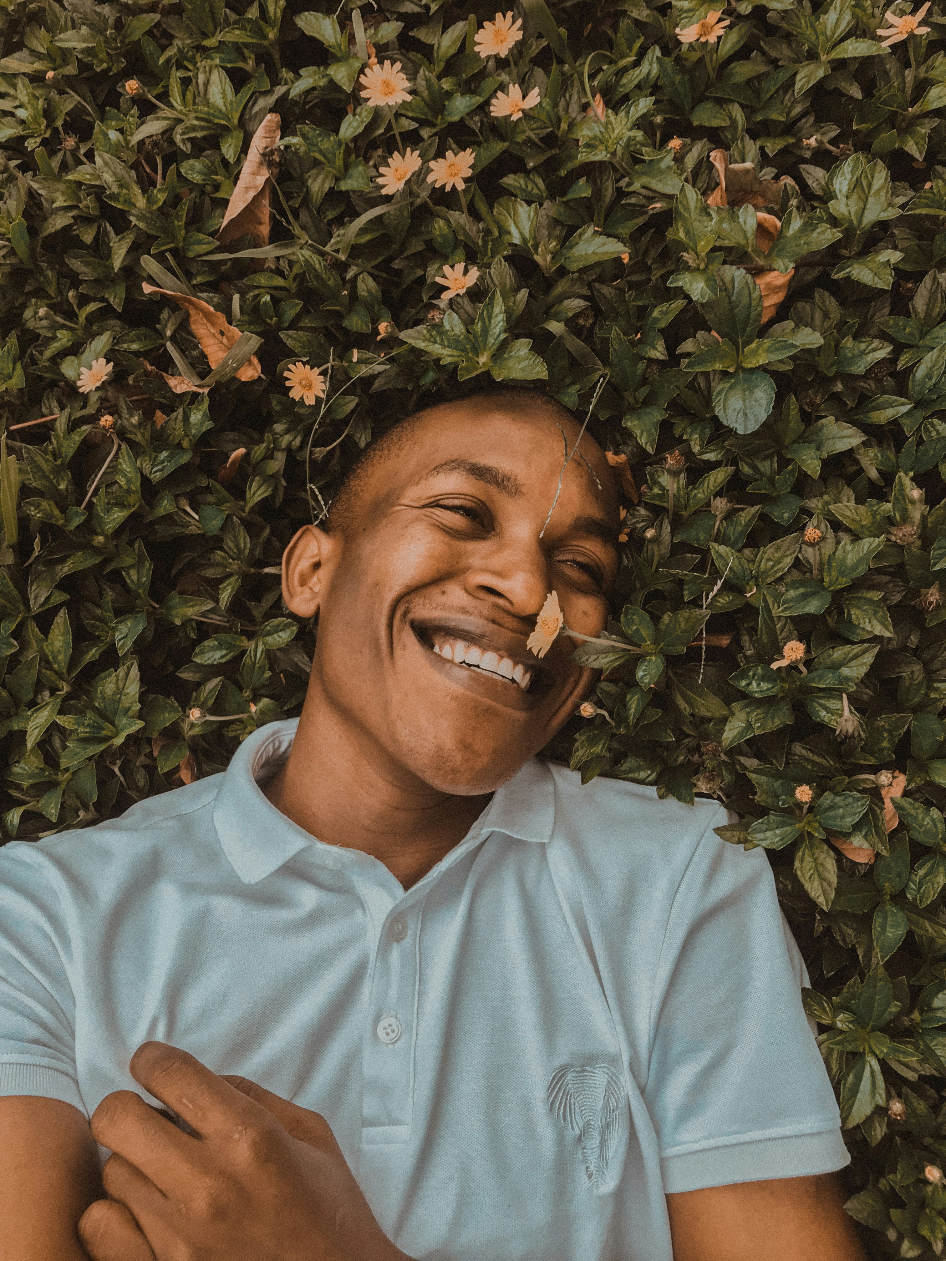 Man lying on his back in a lush green field