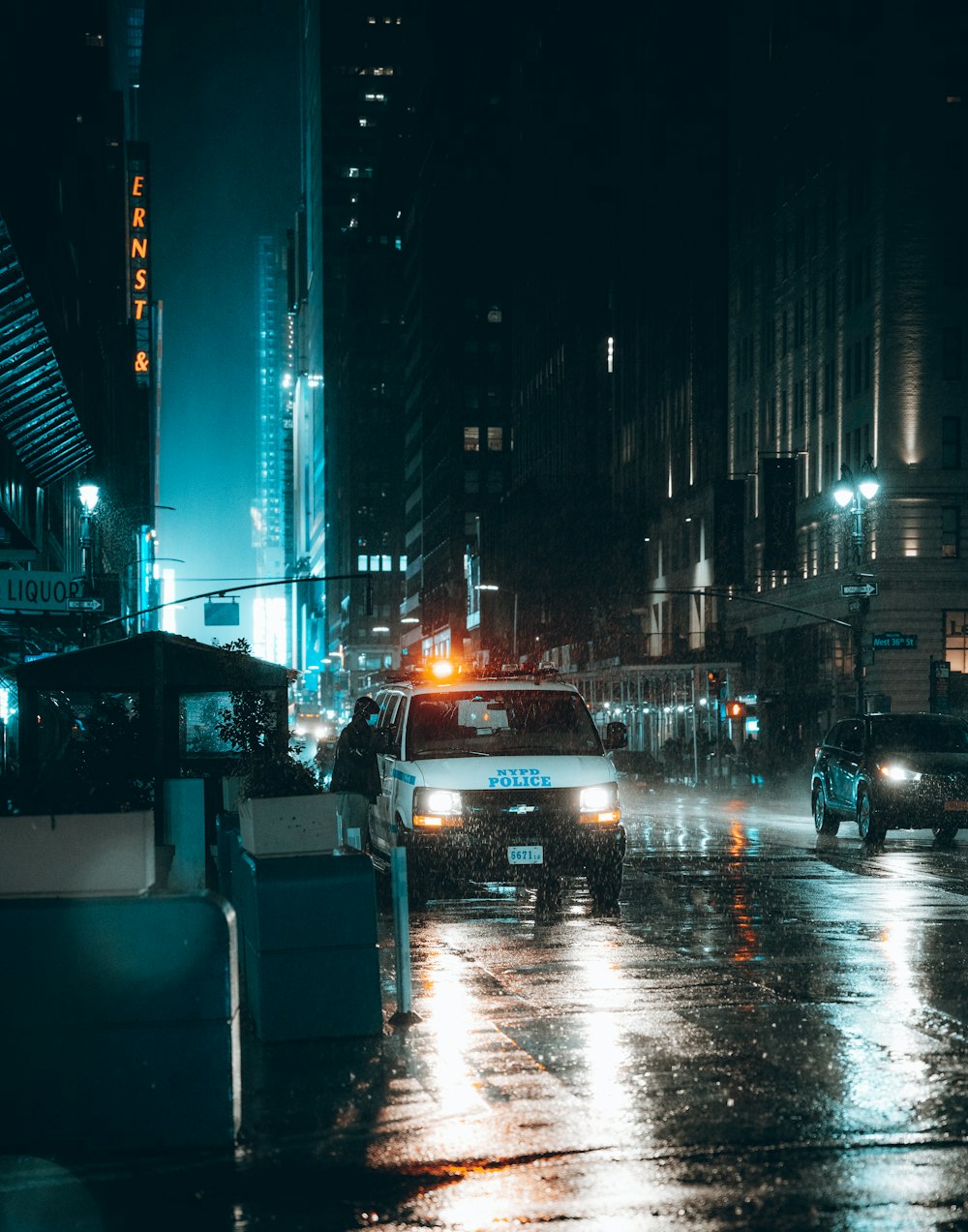 a city street at night with cars driving on it