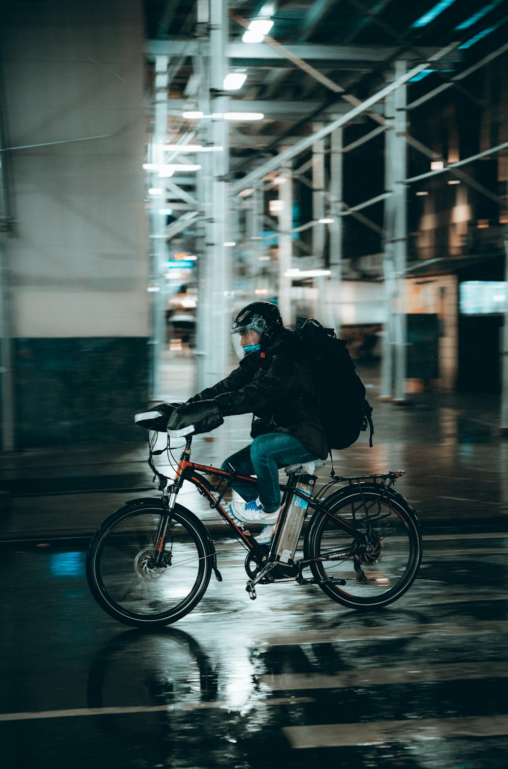 a man riding a bike down a rain soaked street