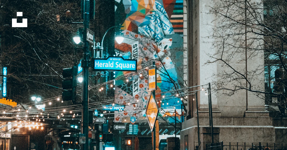 A city street at night with street lights and street signs photo – Free ...