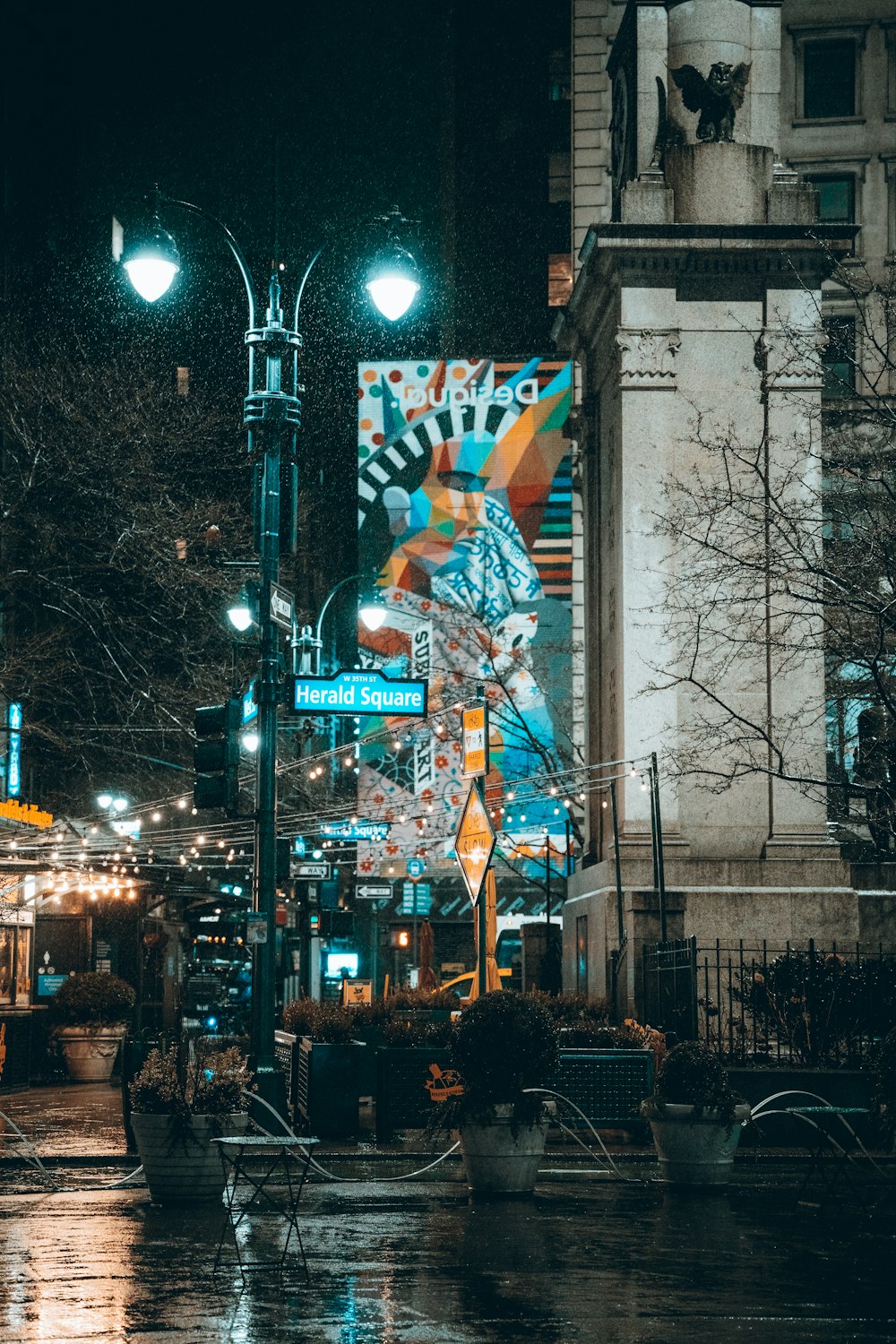 a city street at night with street lights and street signs