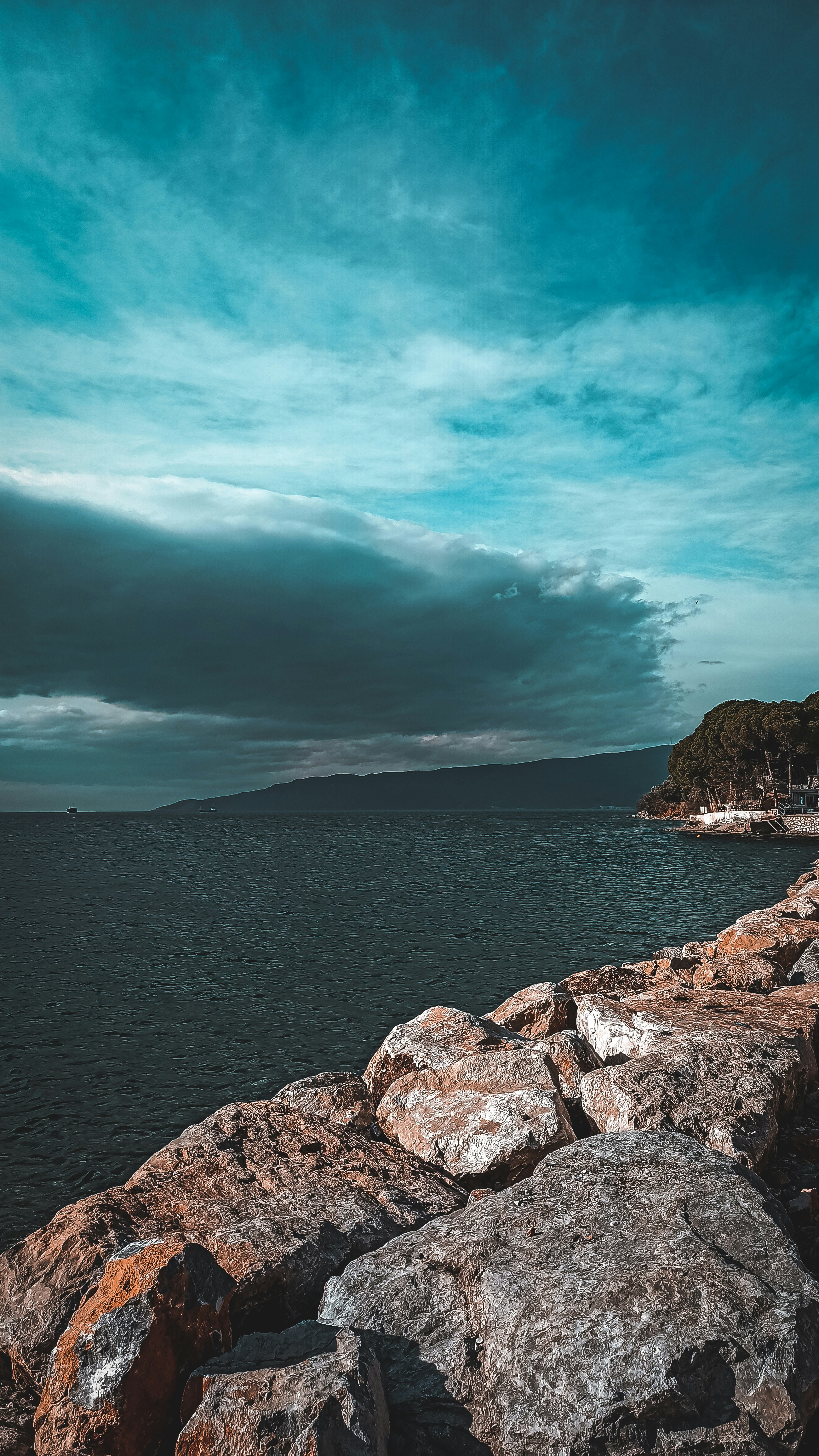 a person sitting on a rock near the ocean
