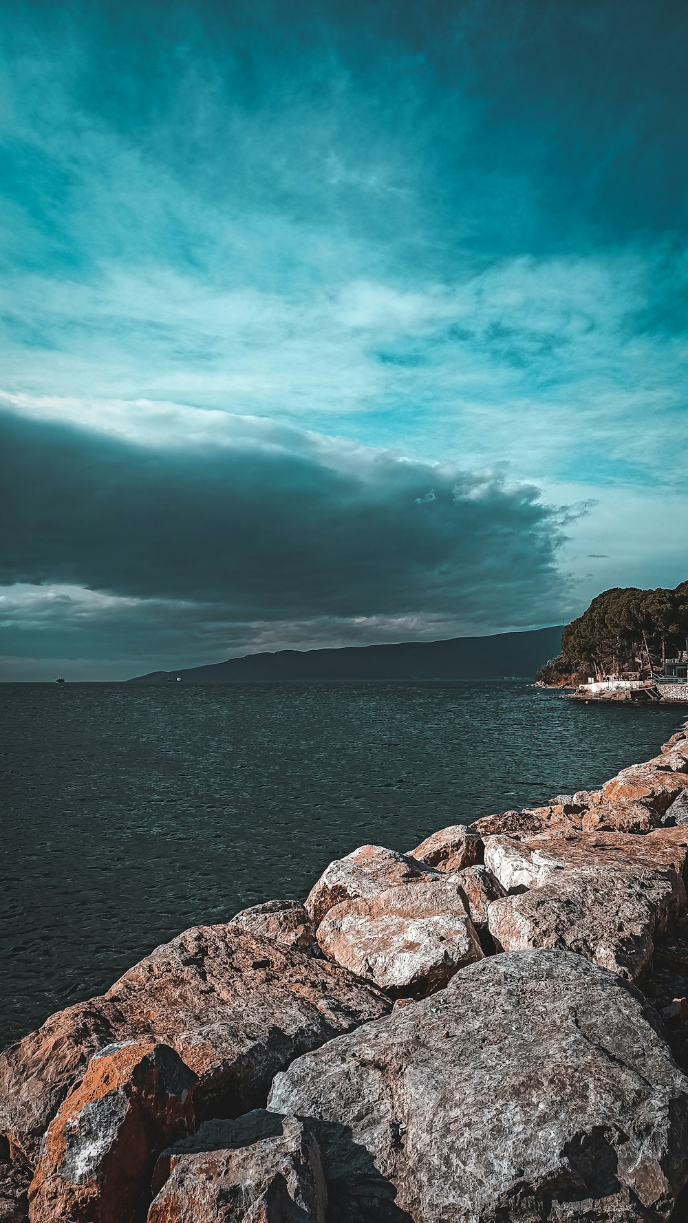 a person sitting on a rock near the ocean