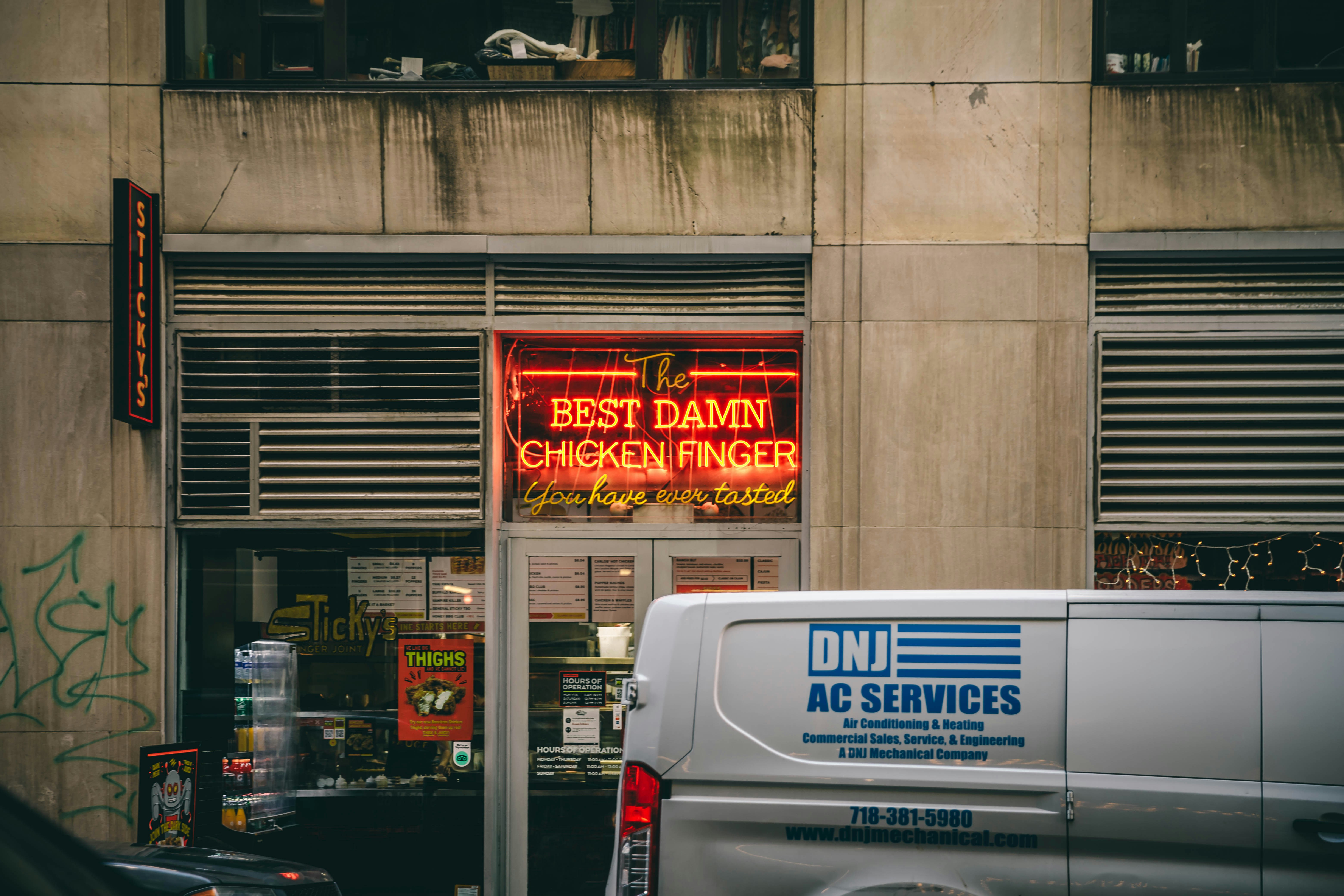 a van parked in front of a building with a neon sign