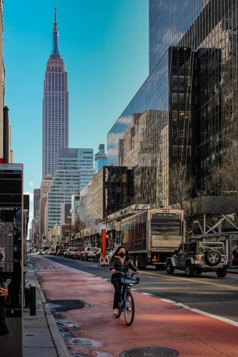 a man riding a bike down a street next to tall buildings