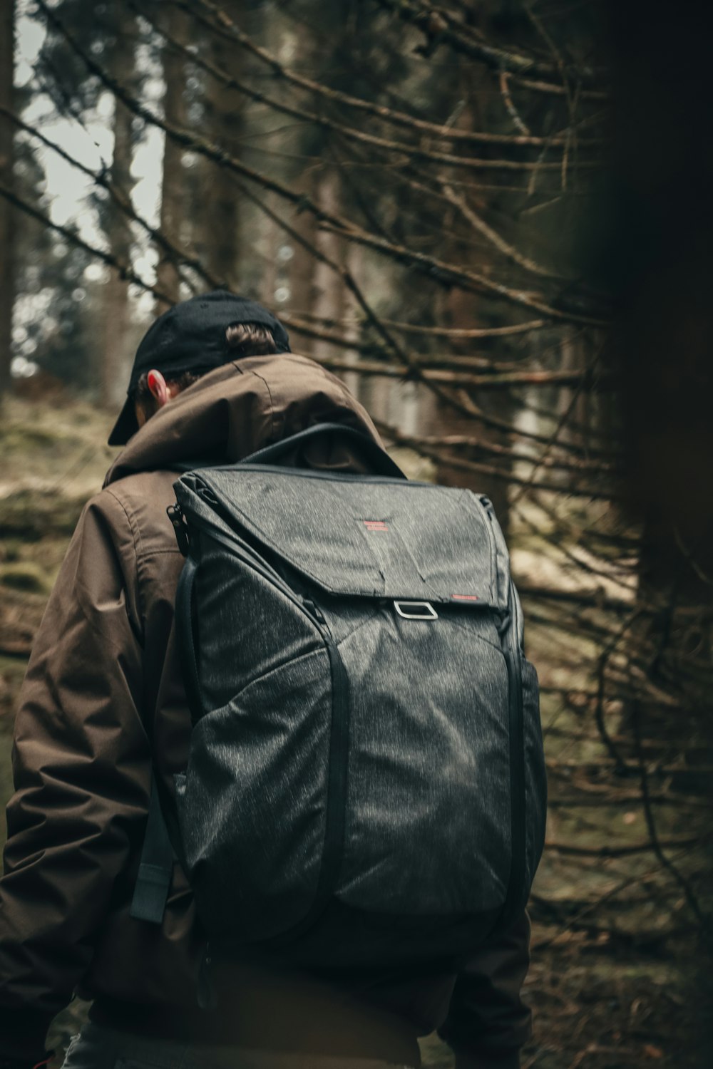 a man with a backpack walking through a forest