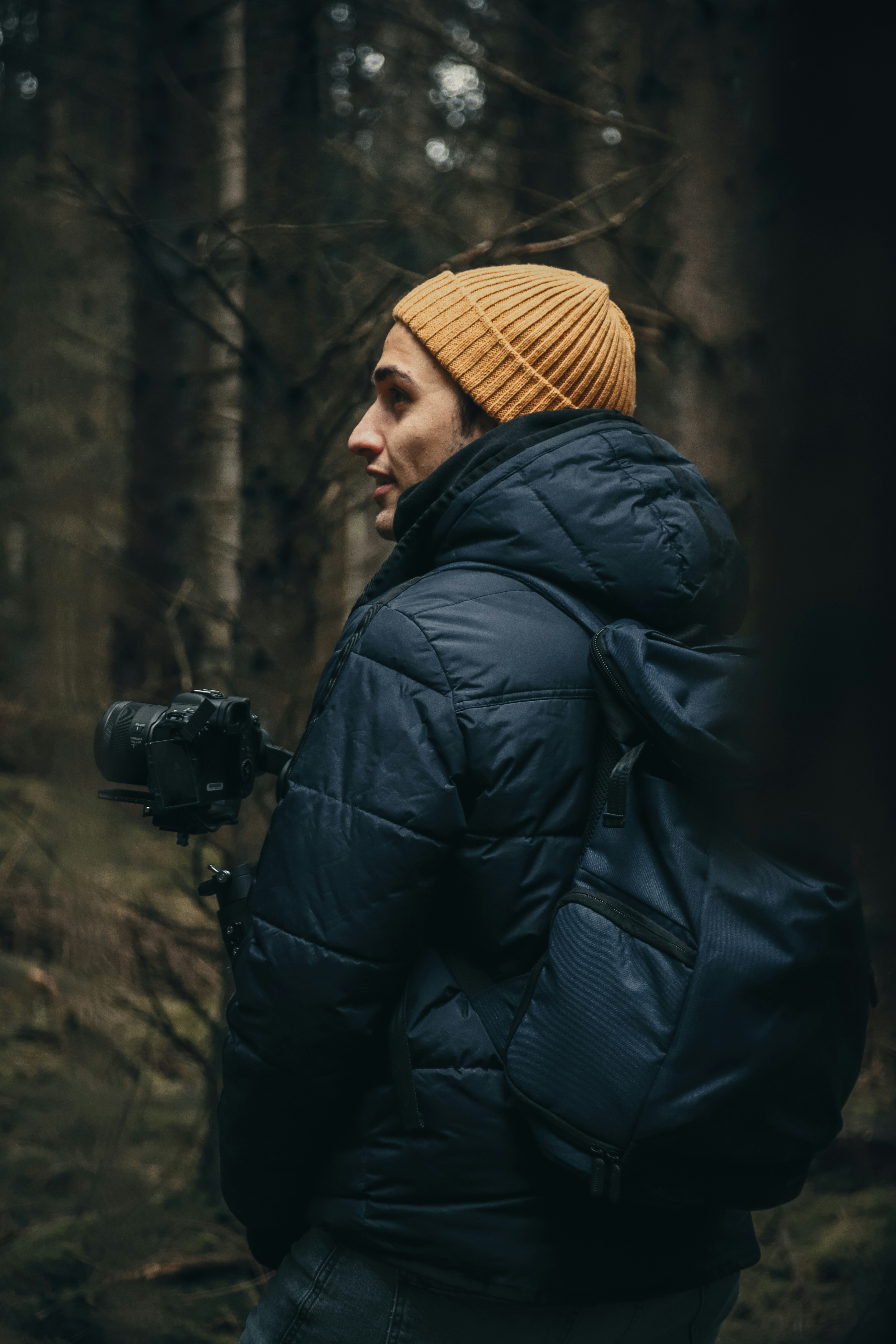 a man standing in the woods with a camera