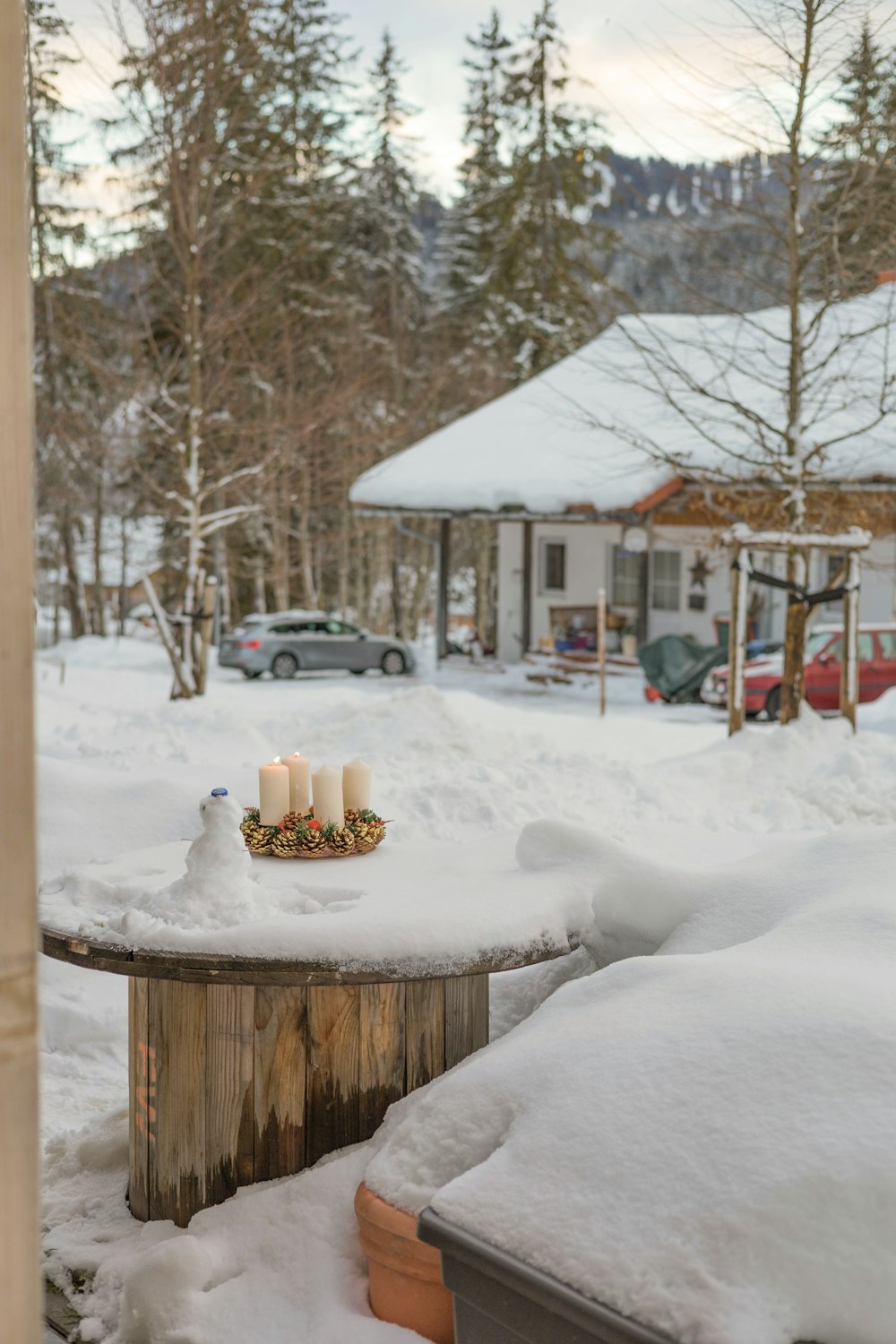 a table covered in snow next to a house
