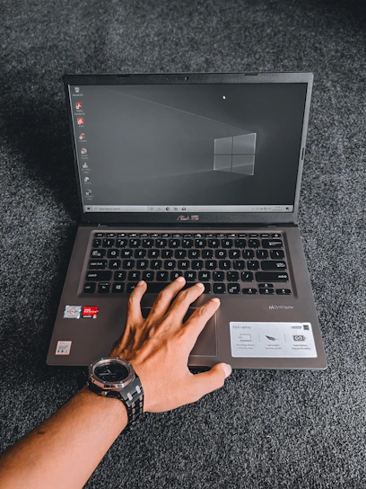 a person using a laptop computer on a carpet