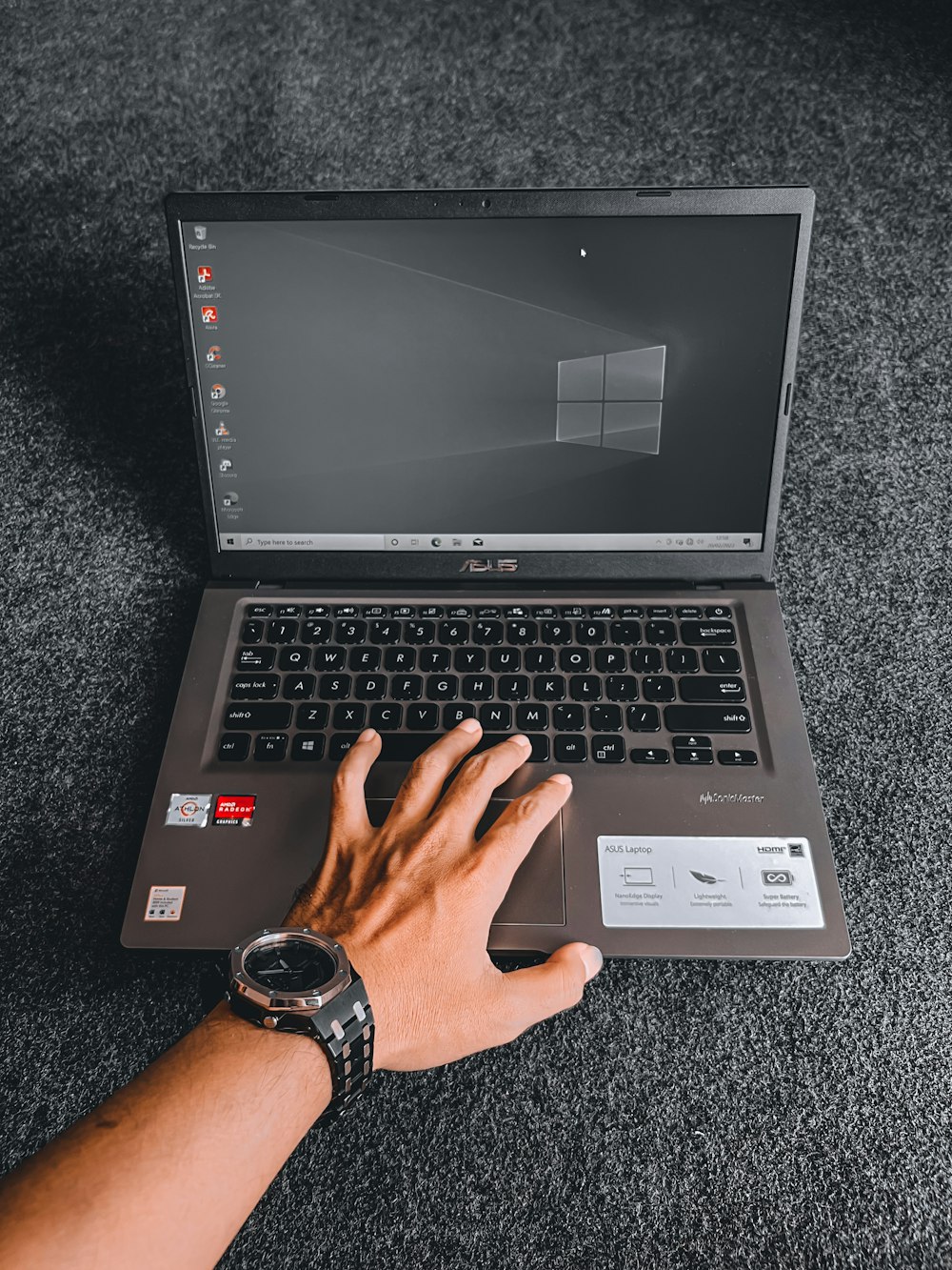 a person using a laptop computer on a carpet