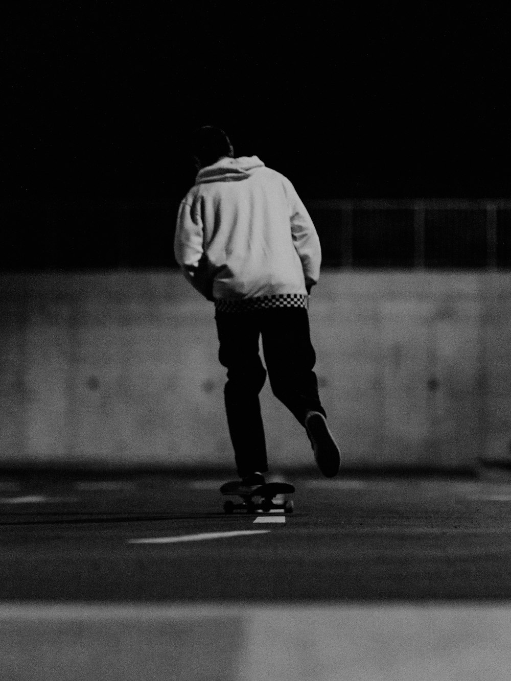 a black and white photo of a man riding a skateboard